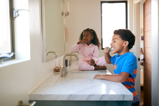 Two Children Brushing Their Teeth In Bathroom At Home - Foto, Imagem