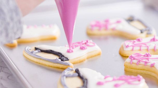 Icing figure skate shaped sugar cookies with royal icing. - Photo, Image