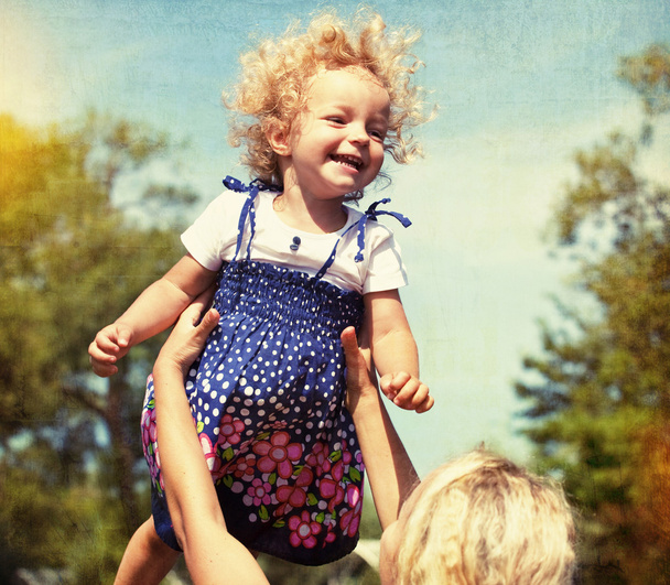 Little girl having fun with mother. vintage paper textured - Foto, imagen
