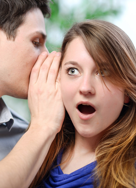 άνθρωπος ψιθυρίζοντας στο αυτί της γυναίκας του έκπληξη - Φωτογραφία, εικόνα