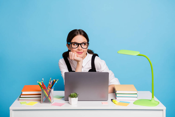 Portrait of her she nice attractive dreamy cheery schoolgirl preparing entering test exam online doing homework task academic subject isolated on bright vivid shine vibrant blue color background - Foto, Imagen