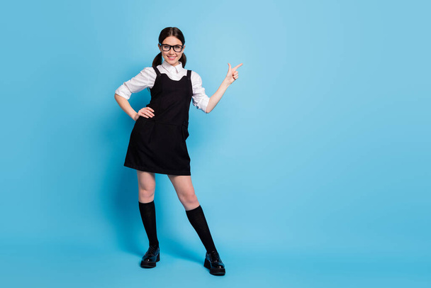 Full length body size view of her she nice-looking attractive brainy genius cheerful schoolgirl demonstrating copy space advert advice isolated over bright vivid shine vibrant blue color background - Zdjęcie, obraz