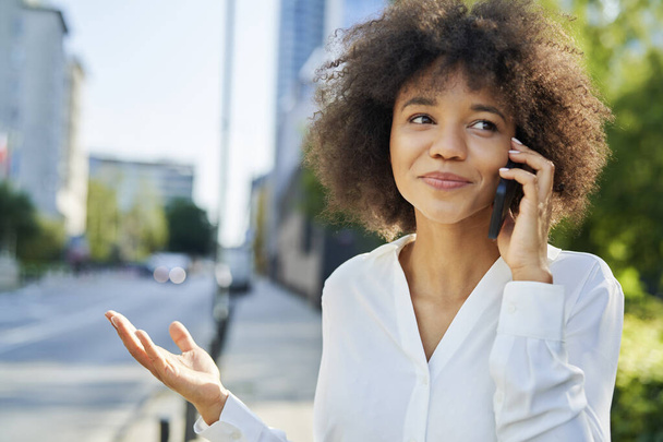 Lähikuva hymyilevä liiketoiminnan nainen puhuu puhelimessa                                - Valokuva, kuva