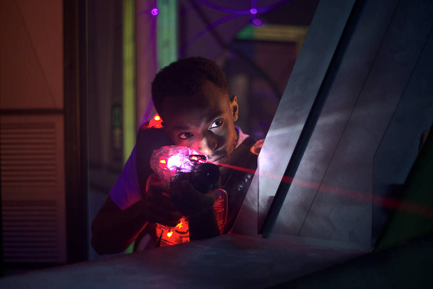 pistola láser jugador de tiro en el laberinto futurista  - Foto, Imagen