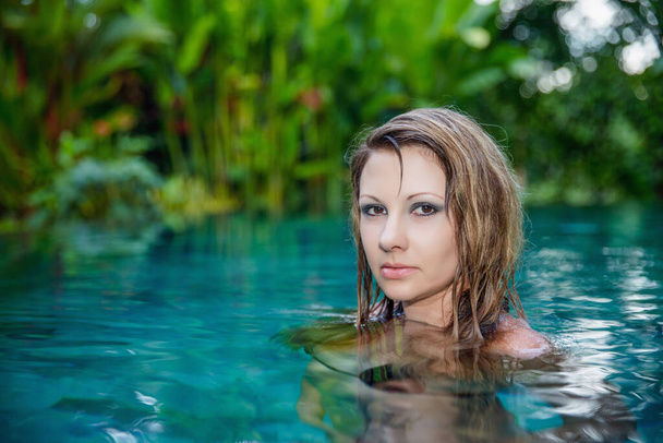 Ritratto di una giovane bionda in posa in piscina - Foto, immagini