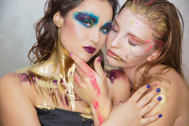 Two young women with creative make-up on the face posing in the studio. - Fotografie, Obrázek