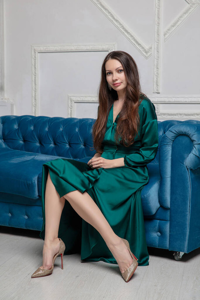 Viehättävä brunette yllään vihreä silkki mekko poseeraa studio - Valokuva, kuva