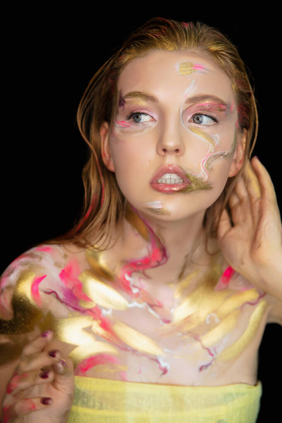 Πορτρέτο μιας χαριτωμένης νεαρής γυναίκας με δημιουργικό μακιγιάζ στο πρόσωπό της - Φωτογραφία, εικόνα
