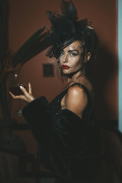 Elegant woman wearing black dress in hotel. Retro style - Fotó, kép