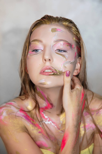 Portrét roztomilé mladé ženy s tvůrčí make-up na její tváři - Fotografie, Obrázek