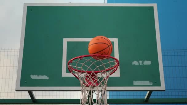 Unerkennbarer Mensch spielt Basketball und schlägt den Ball in einen Korb - Filmmaterial, Video