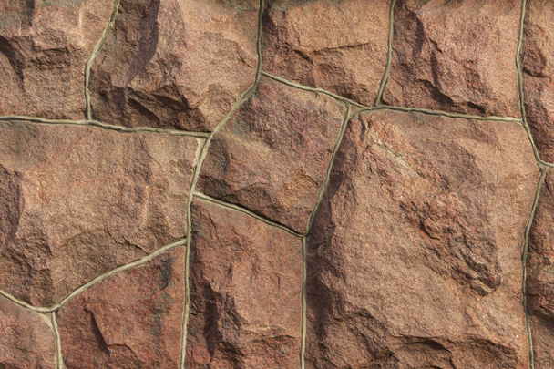 La superficie della muratura è fatta di grandi pietre rosse sgrossate, montate insieme. - Foto, immagini