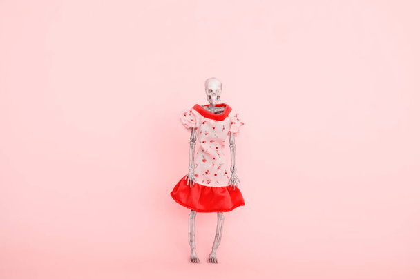 skeleton wearing pink dress on a pink background selective focus - Foto, immagini