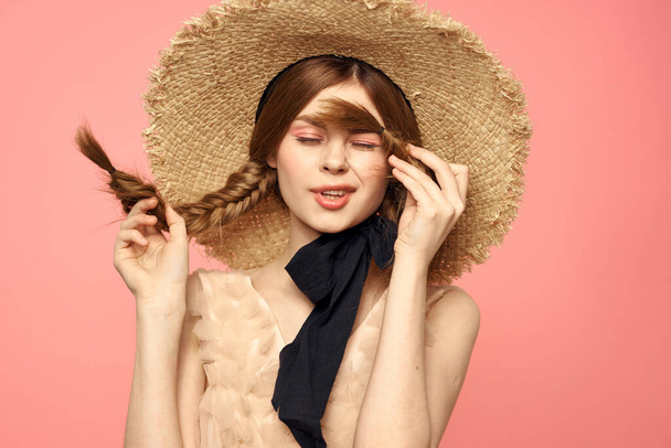 Portrait of a girl in a straw hat on a pink background emotions close-up beautiful face model pigtails - Φωτογραφία, εικόνα