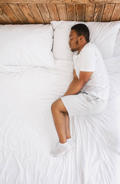 Afroamerikaner schläft im Bett zu Hause, von oben gesehen - Foto, Bild