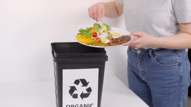 Φωτογραφία ακτιβιστή οικολογίας που πετάει απόβλητα τροφίμων σε δοχείο ανακύκλωσης με οργανική πινακίδα - Πλάνα, βίντεο