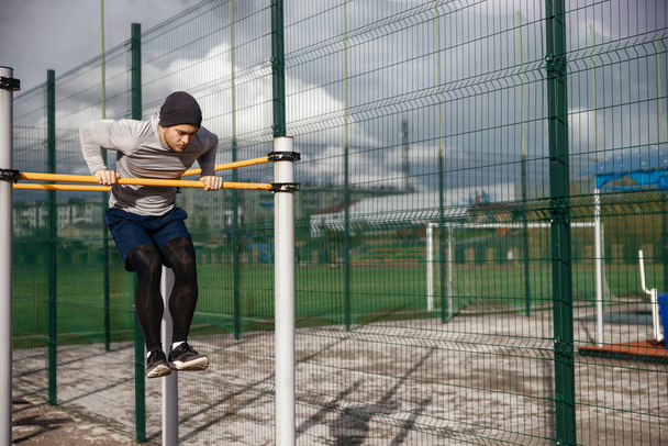 strong athlete does a pull-up on the crossbar. - Photo, Image