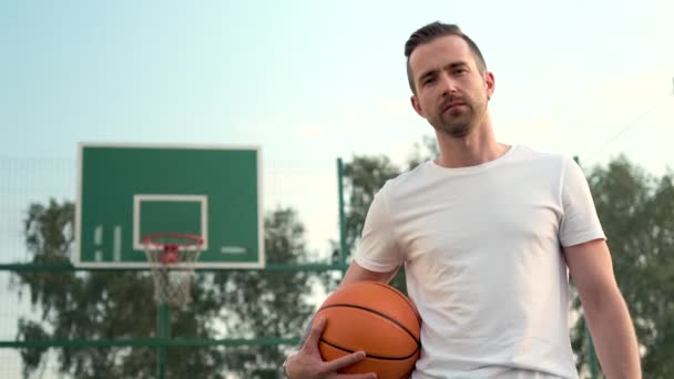 streetball jugador con bola naranja en cancha abierta, retrato - Metraje, vídeo