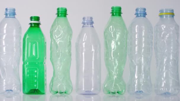 Rompiendo de pie en la fila botellas de agua de plástico vacías sobre fondo blanco aislado - Metraje, vídeo