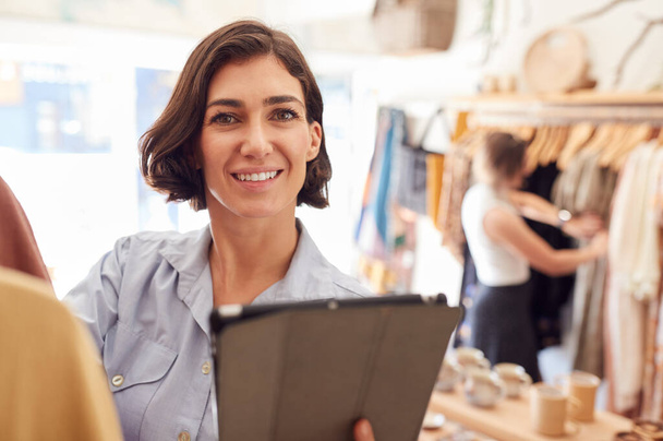 Portrét ženského majitele obchodu s módou Checking stock fotky s digitálním tabletem - Fotografie, Obrázek