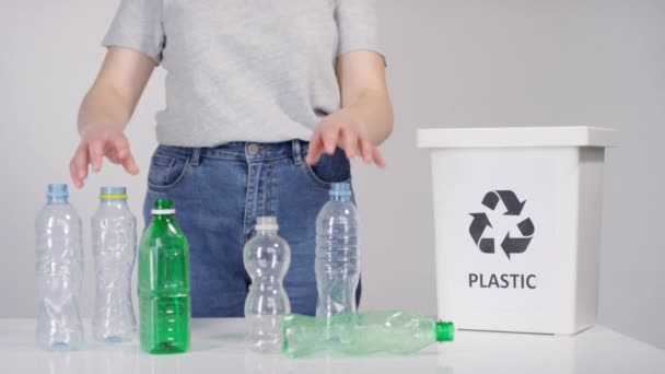 Geri dönüşüm için plastik şişeleri kabın içinde ayıran tanınmayan kadın ekoloji aktivistinin orta bölüm görüntüleri. - Video, Çekim