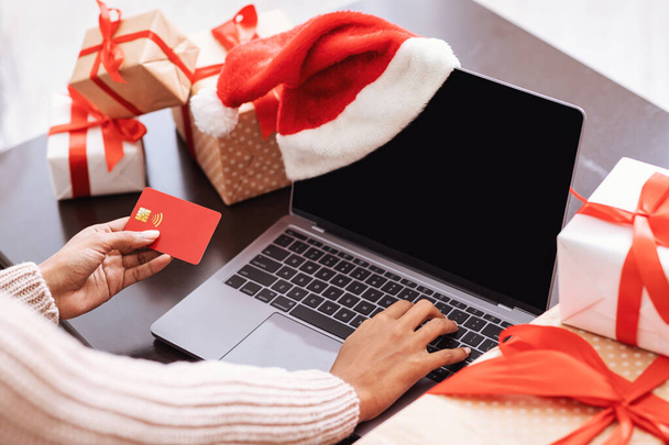 Vánoční nakupování. Černá dáma pomocí notebooku a kreditní karty - Fotografie, Obrázek