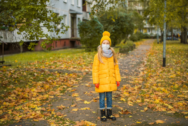Vaalea tyttö yllään hengityssuojain naamio syksyllä - Valokuva, kuva