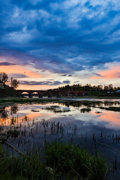 夜遅くに川ベンタ上の古いレンガ造りの橋の風景ビュー。ラトビア・クルディガの春の写真. - 写真・画像
