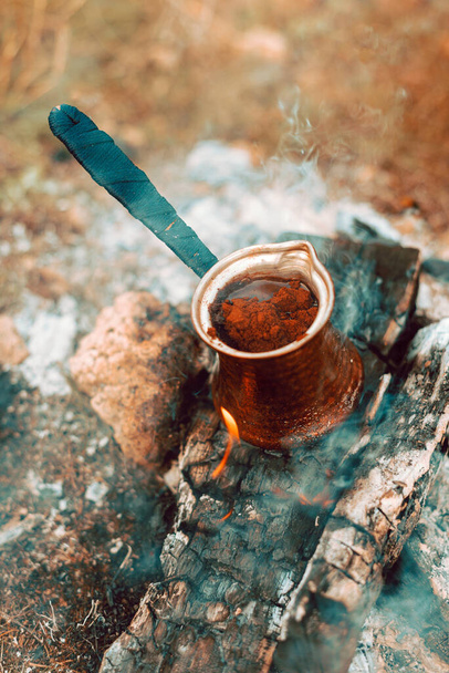 Une cafetière turque sur du bois brûlant avec du café à l'intérieur - Photo, image