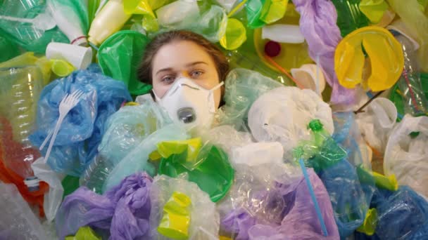 Imágenes de vista superior de la adolescente caucásica cubierta con bolsas de plástico y botellas que yacen en la máscara respirando pesadamente - Metraje, vídeo