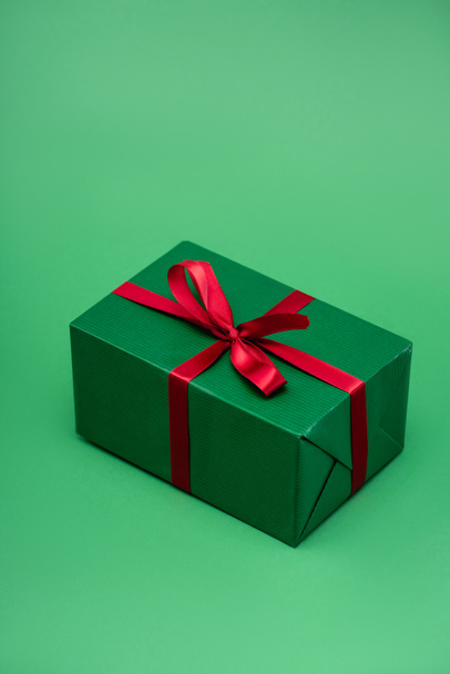 colorful gift box with red ribbon on green background - Foto, imagen
