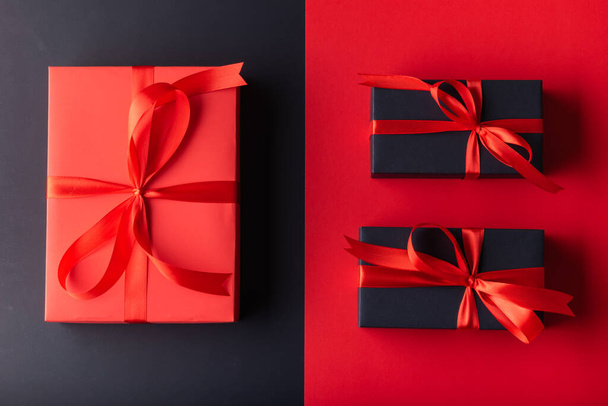 1 Big Red gift box with red ribbon on half red color background and 2 black gift box on half black color background. 11.11 single day, Monday, Friday sale concept - Valokuva, kuva
