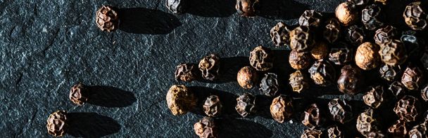 Black pepper closeup on luxury stone background as flat lay, dry food spices and recipe ingredient - Zdjęcie, obraz