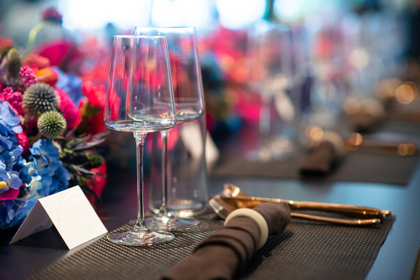 copas de vino vacías instaladas en la vibrante mesa de decoración de flores - Foto, imagen