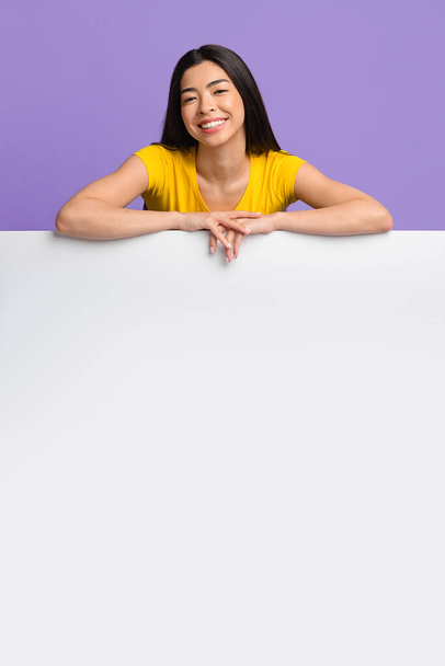 Reklam için bedava yer. Beyaz tahtaya yaslanan neşeli Asyalı Kadın - Fotoğraf, Görsel