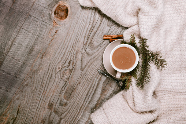 Tasse à café chaude enveloppée dans une couverture confortable sur une table en bois - Photo, image