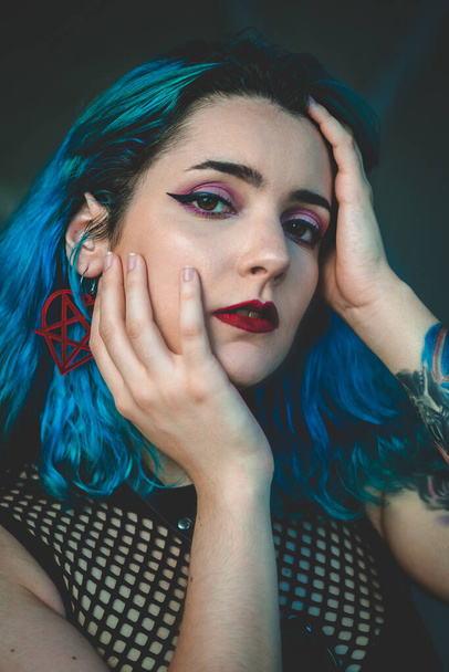 A portrait of a stylish blue-haired young woman with mesh blouse - Foto, Bild