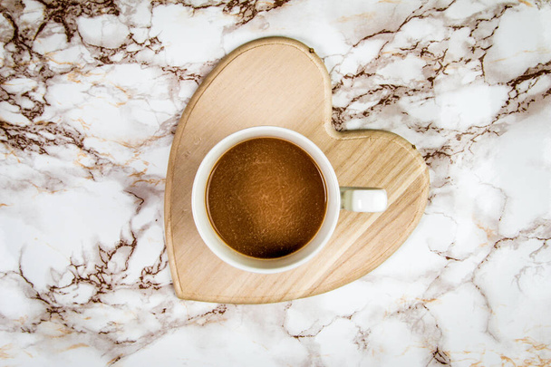 Καφές σε θήκη σχήματος καρδιάς σε μαρμάρινο φόντο  - Φωτογραφία, εικόνα