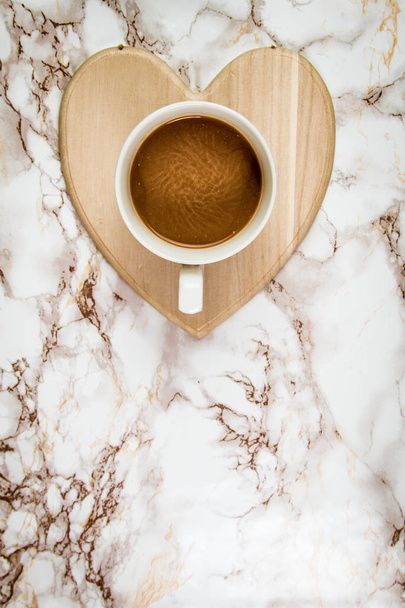 Кава на тримачі у формі серця на мармуровому фоні
  - Фото, зображення