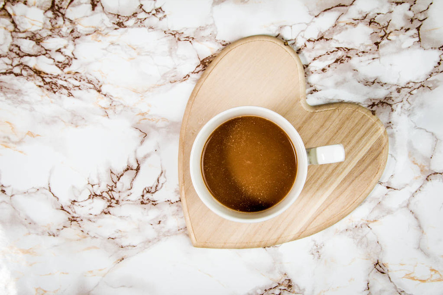 Кофе на мраморном фоне в форме сердечка - Фото, изображение