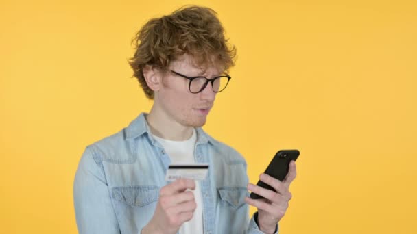 Online winkelen op Smartphone door roodharige jongeman, gele achtergrond  - Video
