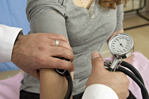 Nahaufnahme eines Arztes, der den Blutdruck eines Patienten überprüft - Foto, Bild