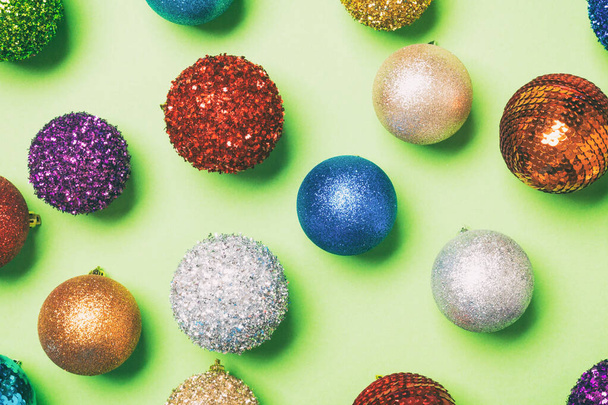 Top view of creative holiday baubles on colorful background. Christmas ornament concept. - 写真・画像