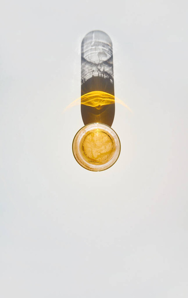 A top view of a glass of beer with the shadow reflected on the white table - Φωτογραφία, εικόνα