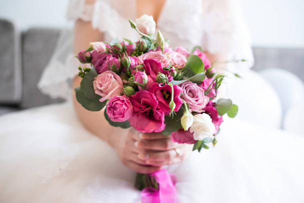 A closeup shot of a bride holding a pink flower bouquet - wedding concept - Foto, Imagem