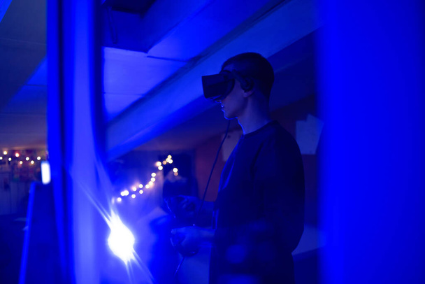 Чоловік вдома в окулярах віртуальної реальності. Тримає контролери в руках. Хлопець грає в ігри vr
 - Фото, зображення