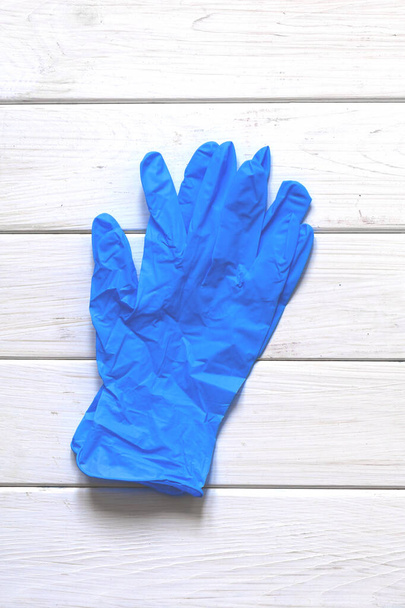 A pair of thin blue medical latex gloves and face shield on a white background. Disposable rubber medical gloves and mask. Protective subjects - Photo, Image