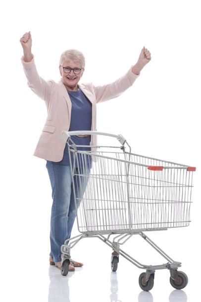 in full growth. a very happy old woman with a shopping cart - Foto, afbeelding
