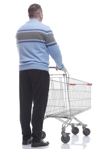 rear view. casual man with a cart standing in front of a white screen - Foto, imagen