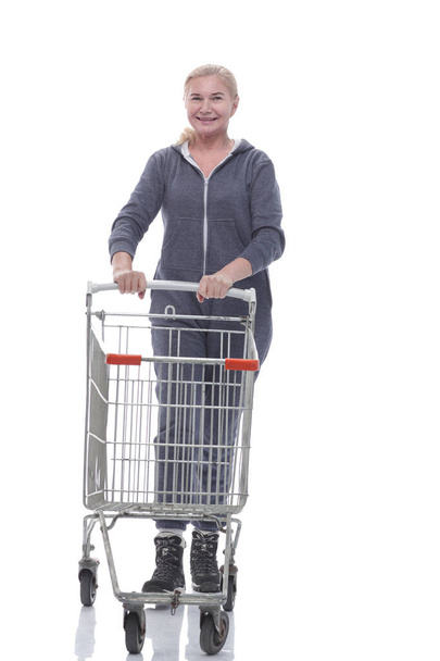 in full growth. smiling woman in casual clothes with shopping cart - Фото, изображение